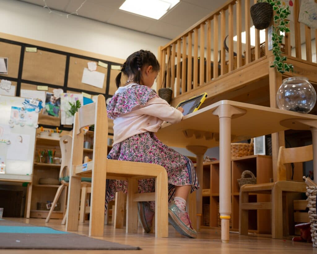 A young girl using her tablet to learn from home.